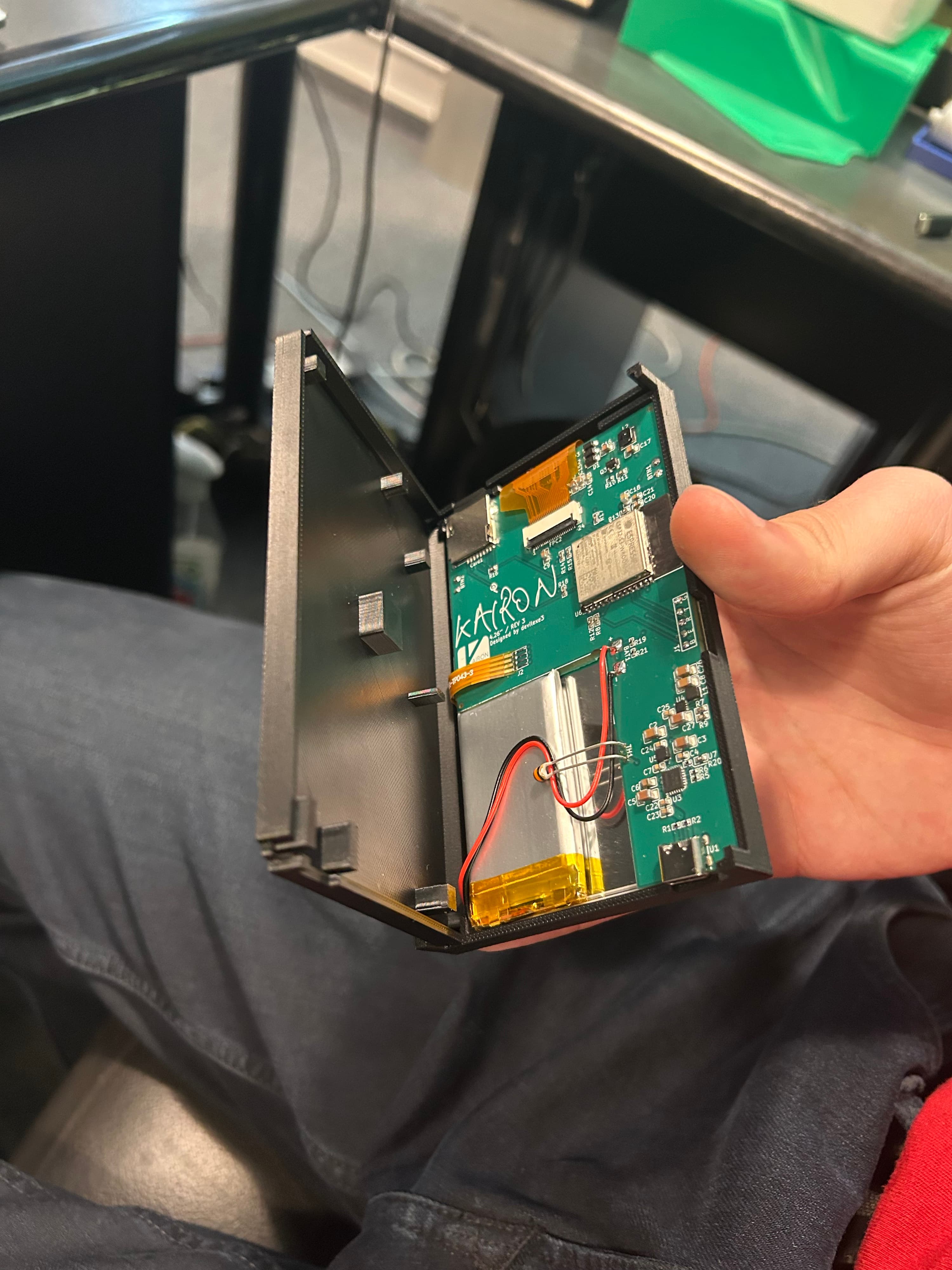 The Kairon enclosure opened to show its custom PCB, battery, and display connections
