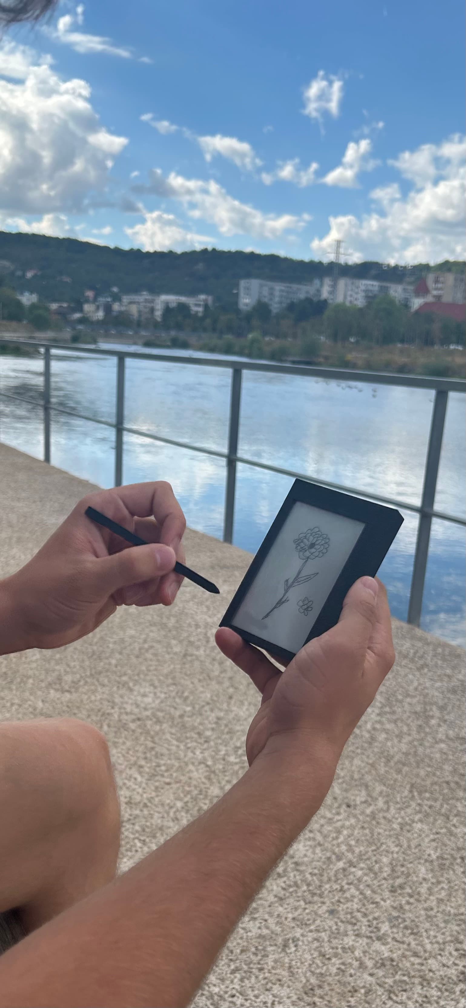 A person sketching a flower on Kairon outdoors