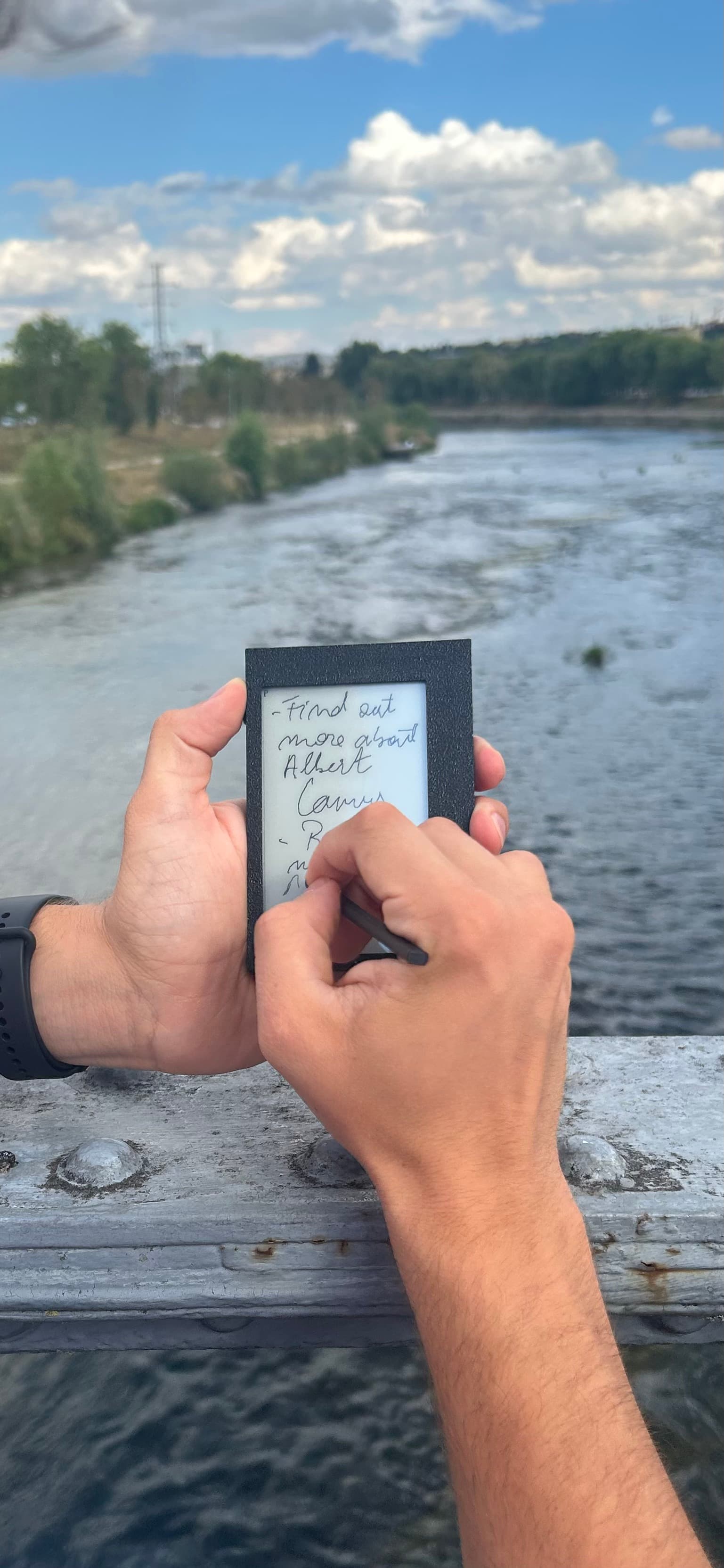 Writing a note on Kairon outdoors on a bridge